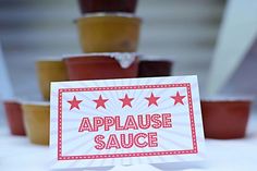 there is a sign that says applause sauce in front of some cups on the table