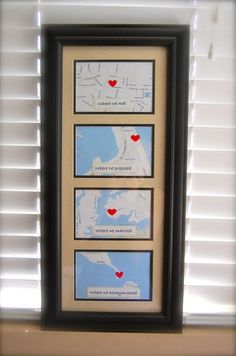 three framed maps with red hearts on them in front of a white window sill