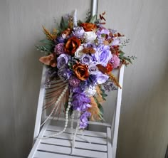 a bridal bouquet sitting on top of a white chair