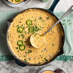 a skillet filled with cheese sauce and topped with jalapenos