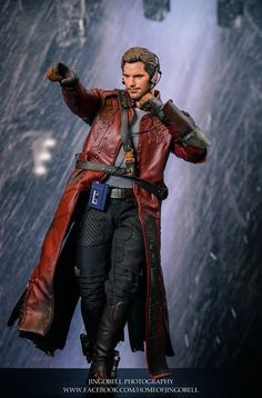 the action figure is wearing a red leather coat and holding his hand out in front of him