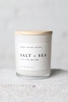 salt and sea candle sitting on top of a white countertop next to a wall