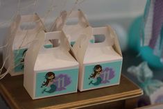 two little mermaid boxes sitting on top of a table