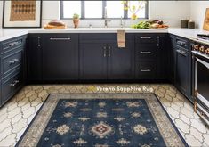 a kitchen with black cabinets and white counter tops, an area rug in the middle