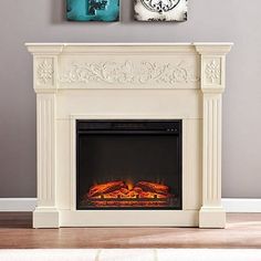 a white fireplace with two paintings on the wall