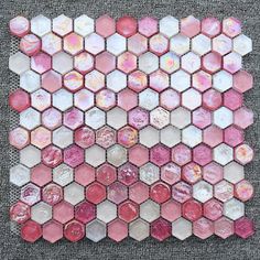 pink and white hexagon tiles are arranged in the shape of an abstract pattern