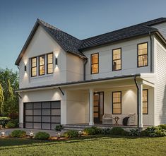 a two story house with white siding and windows