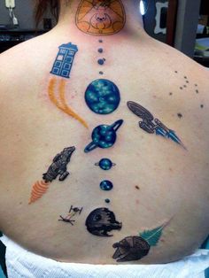 the back of a woman's neck with tattoos on her body and various space related items