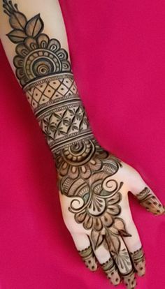 a woman's hand with henna tattoos on it