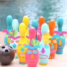 several colorful painted bowling pins next to a pool