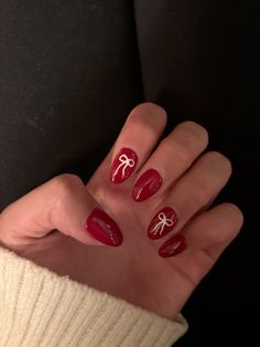 red almond nails with bows Almond Short Nails Christmas, Red And Gold Bow Nails, Red Nails W Design, January Nails Aesthetic, How To Paint Bows On Nails, Red And White Bow Nails, Minimalist Christmas Nails Almond