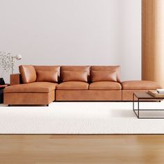 a living room with a couch, coffee table and vase on the floor in front of it