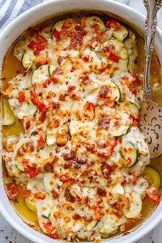 a casserole dish with zucchini, tomatoes and other vegetables in it