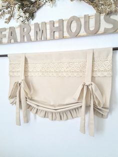 a pair of beige garters hanging on the wall next to a sign that says farmhouse