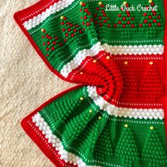 two red and green knitted christmas sweaters with bows on the sides, one is made out of crochet