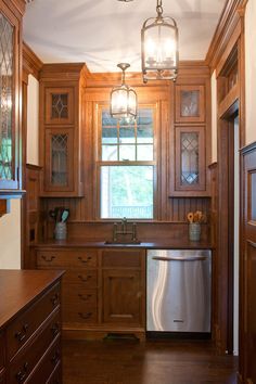 a kitchen with wooden cabinets and stainless steel dishwasher