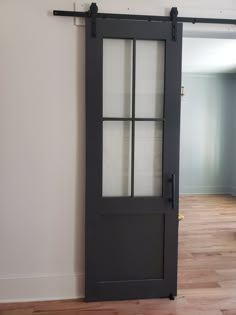 an empty room with a sliding door and hard wood flooring