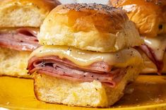 two ham and cheese sliders on a yellow plate