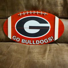 a football sitting on top of a couch with the word go bulldogs painted on it