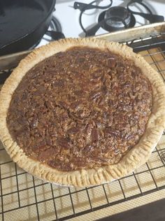 an uncooked pie sitting on top of a metal rack next to a stove