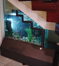 a fish tank sitting on top of a counter next to a stair case