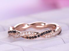 a rose gold ring with black and white diamonds