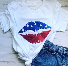 a white shirt with red, white and blue lipstick on it next to denim shorts