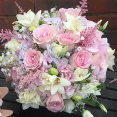 a bouquet of pink and white flowers on a bench