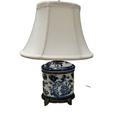 a blue and white lamp with a shade on it's base is sitting in front of a white background