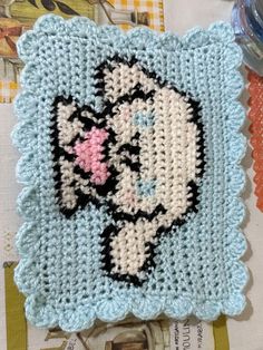 a close up of a crocheted square with a cat on it's face