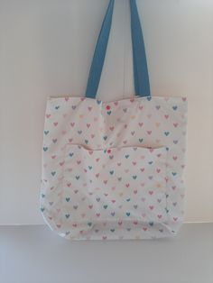 Hearts Tote or Shoulder Bag Brighten up your day with our adorable Hearts Tote or Shoulder Bag! This charming accessory features a delightful pattern of colorful hearts, perfect for adding a touch of fun and whimsy to your everyday look. Materials: Made from high-quality poplin cotton fabric for durability and a soft feel Dimensions: Generous size of 45 cm x 45 cm (17.7 in x 17.7 in), providing ample space for all your essentials Features: Sturdy blue cotton straps for comfortable shoulder carrying Convenient front pocket for easy access to small items Secured with a playful plastic colorful button for added charm Lightweight yet durable, perfect for daily use Usage: Ideal for shopping, school, work, or casual outings Easy to fold and pack, making it a great travel companion. Inspiration: Rectangular Bags With Heart Print For Daily Use, Daily Use Rectangular Bag With Heart Print, Pink Heart Print Bag For Everyday Use, Pink Heart Print Bags For Everyday Use, Casual Heart Print Bags For Daily Use, Cute Heart-shaped Shoulder Bag For Daily Use, Pink Heart-shaped Bag For Everyday Use, Casual Heart-shaped Shoulder Bag For Gift, Casual Heart-shaped Shoulder Bag As Gift