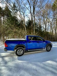 a blue pick up truck parked in the snow