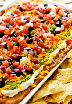 a platter filled with nachos and tortilla chips on top of a table