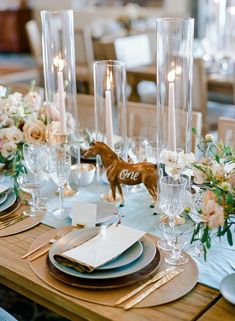 the table is set with plates, silverware and candles for an elegant wedding reception