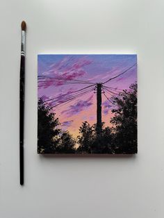 an acrylic painting of power lines in the distance with a brush next to it