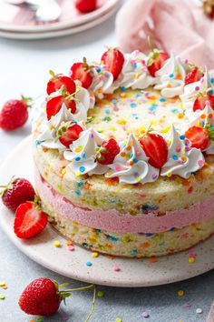 a birthday cake with strawberries and sprinkles on the top is ready to be eaten