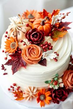 a white wedding cake decorated with flowers and leaves