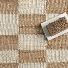 a wooden stamp sitting on top of a checkered table cloth with a white plate