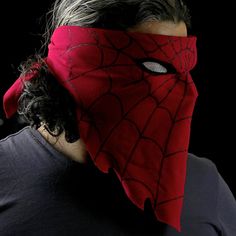 a man wearing a red mask with spider - man's face on his head