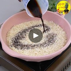 someone is pouring rice into a pink bowl