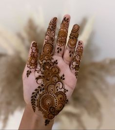 a woman's hand with henna tattoos on it