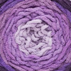 a pile of purple and white towels sitting on top of each other in a circle