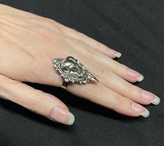 "This richly detailed antiqued silver ring is accented with a raven skull, set in a lovely frame. It measures 1 1/2\" tall and 1\" wide. Ring is adjustable hypoallergenic stainless steel. Matching earrings and pendant are listed in our store." Antique Silver Skull Ring Gift, Antique Silver Skull Ring As Gift, Antique Silver Skull Ring For Gift, Nickel-free Silver Gothic Skull Ring, Collectible Silver Gothic Skull Ring, Collectible Gothic Silver Skull Ring, Silver Gothic Skull Ring Collectible, Silver Gothic Skull Ring, Collectible, Skull Cameo