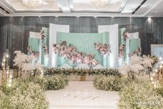 an elegant wedding setup with flowers and greenery on the stage at this event venue