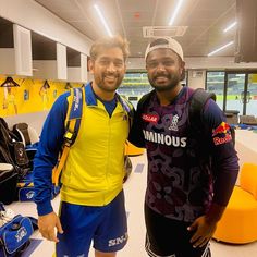 two men standing next to each other in a room with yellow and blue decor on the walls