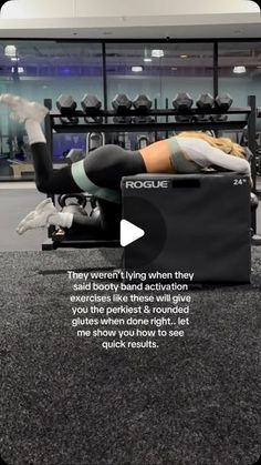 a woman laying on top of a box in a gym