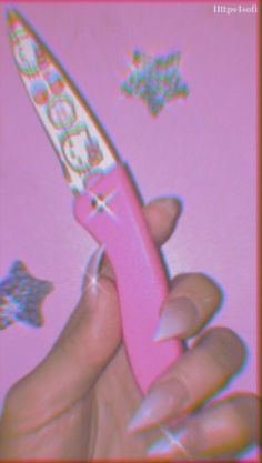 a hand holding a pink toothbrush with hello kitty decorations on it's side