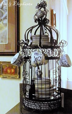 a birdcage filled with lots of different things on top of a table