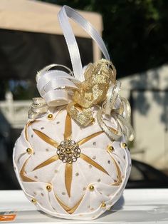 a white and gold christmas ornament sitting on top of a table