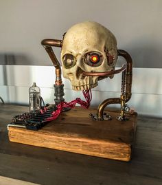 a skull sitting on top of a wooden table next to an electrical wire and circuit